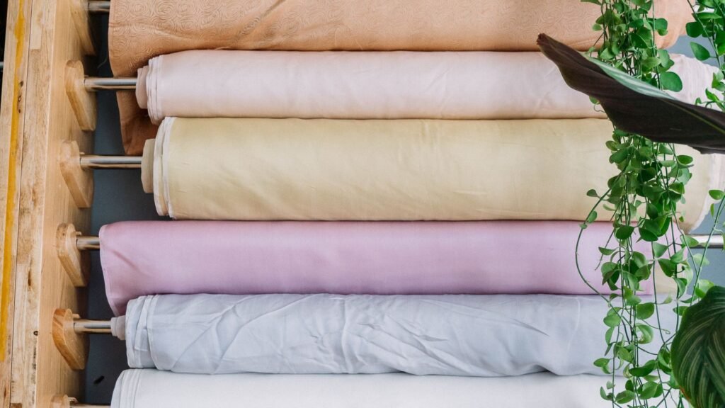 Pastel fabric rolls stacked on wooden shelves